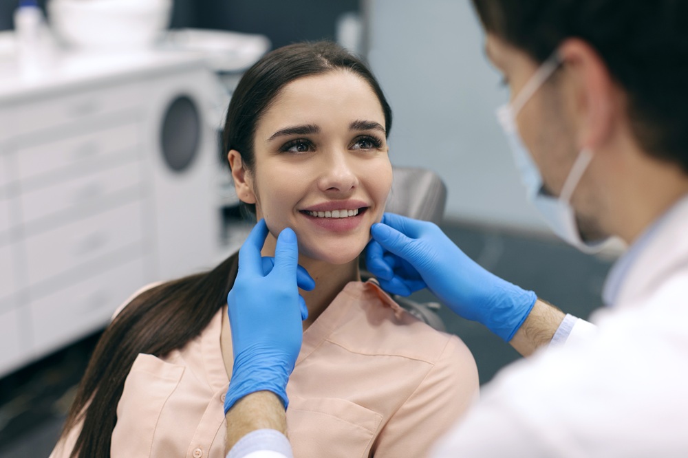 All-On-X Consultation in Irvine: Provider Evaluating a Patient's Smile Dental provider examining a patient's jaw and smile during a consultation