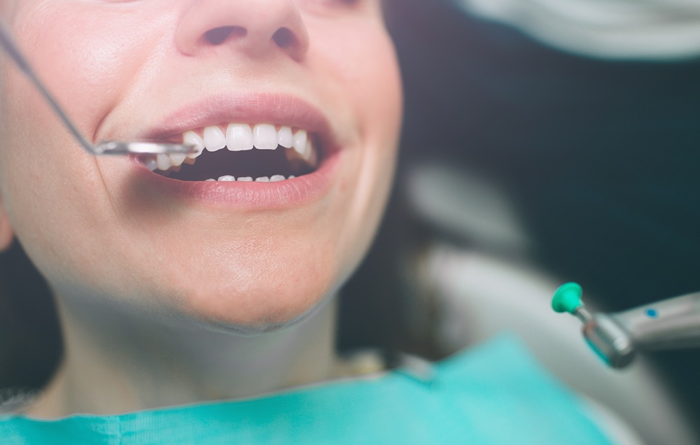 Close-up of a patient's teeth being examined with a dental instrument during treatment