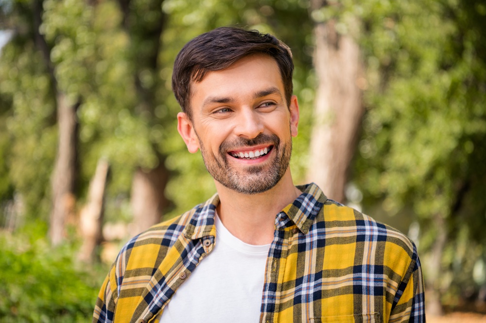 All-On-X Implants in Irvine: A Confident Smile for Everyday Life Smiling man outdoors showing a bright, confident smile
